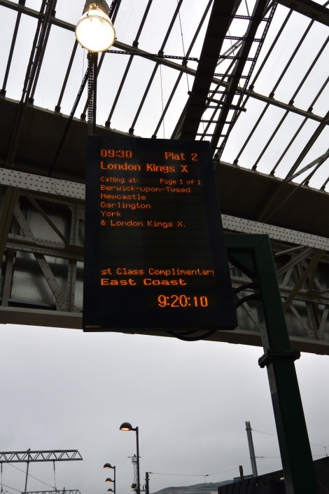 Digital screen displaying train info at Waverly Station, Edinburgh, Scotland.